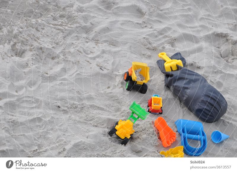 Spielzeugautos und Spielzeug aus Plastik am Sandstrand Strand Vogelperspektive Auto LKW Lastwagen spielen Sommer Sandkasten HArke Förmchen Sandspielzeug sandeln