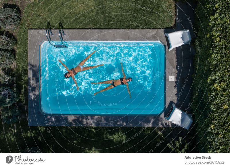 Entspannte Frauen schweben im Pool Schwimmer sich[Akk] entspannen Lügen Sommer ruhen Kälte Wasser Hof Hinterhof Lifestyle Feiertag Freund Zusammensein Erholung