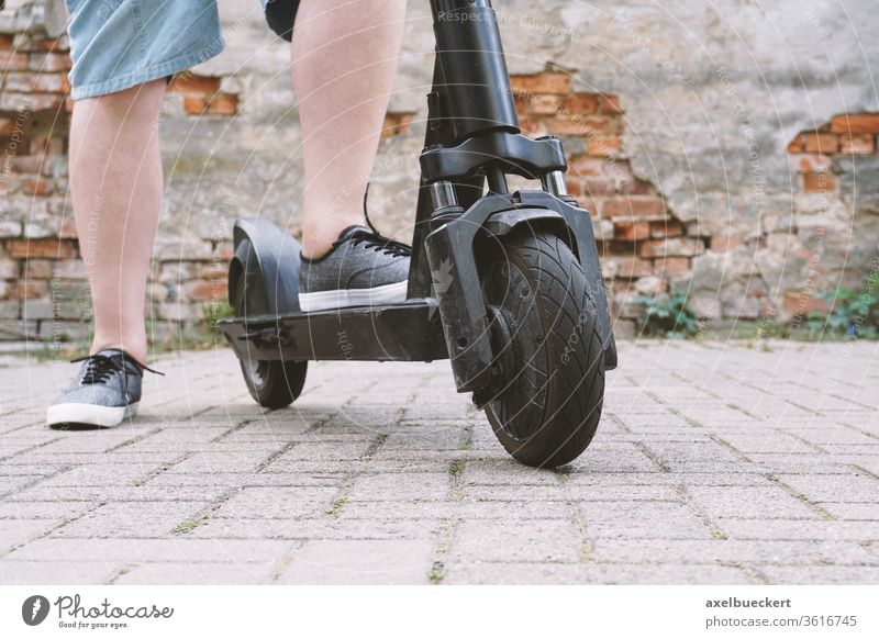 Beine eines nicht erkennbaren Mannes mit E-Scooter E-Roller Tretroller e-Mobilität Mikromobilität Lifestyle trendy Escooter Verkehr elektrisch Person Fuß
