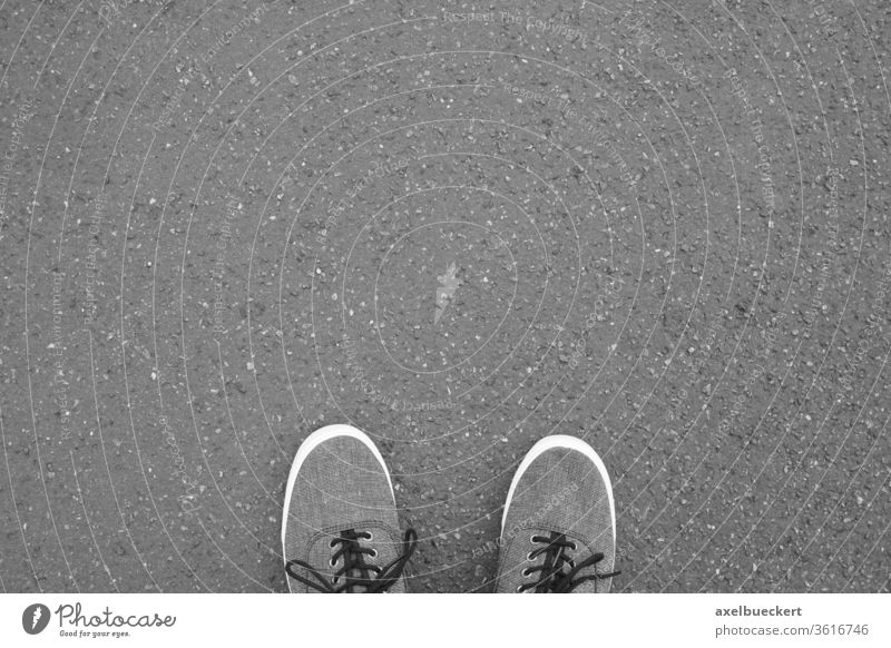 Füße in Leinenschuhen auf asphaltierter Straße stehend Fuß Schuh Selfie Asphalt Fußballspiel Leinwand Schuhe Stehen Turnschuh Rollfeld Personal Perspektive