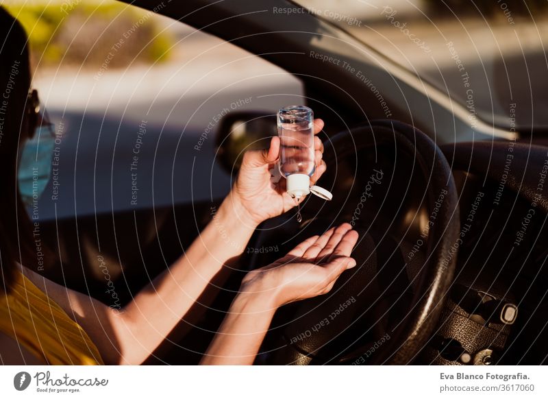 nicht erkennbare Frau, die vor der Fahrt im Auto ein desinfizierendes Alkoholgel verwendet hat. Konzept der sauberen Hände Desinfektionsmittel Gel PKW