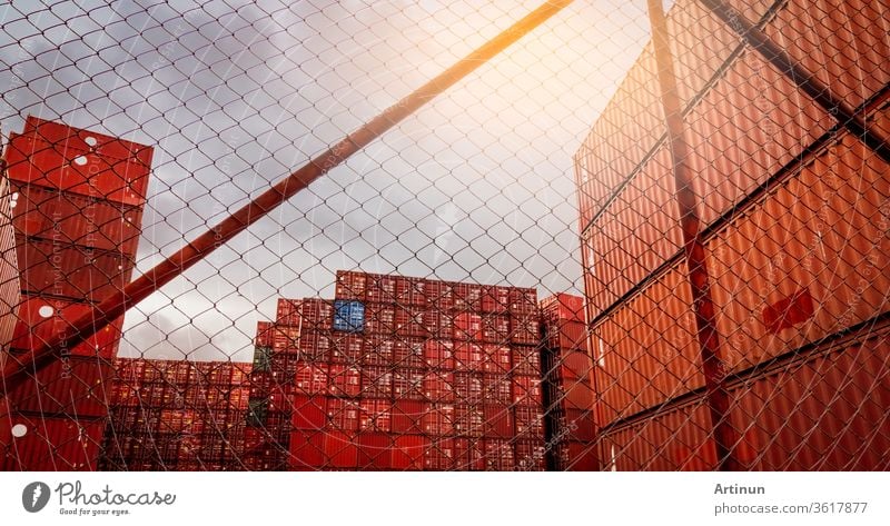 Blick vom Zaun auf gestapelten roten Container. Container-Logistik. Fracht und Versand. Import- und Exportlogistikgeschäft. Container-Frachtbahnhof. Logistische Industrie. Container für Lkw-Transport.