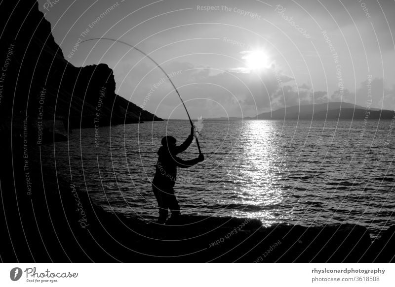 Junger Mann fischt mit Federn auf Makrele B+W Insel Mull Schottland schwarz weiß schwarz auf weiß Fischen Fischerfedern Angelrute Stab Linie Jagd Sport