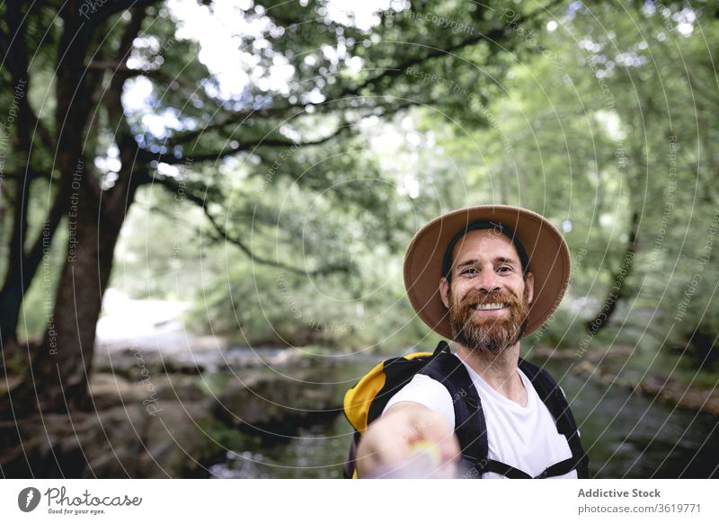 junger Mann mit Bart wandert an einer Seeroute mit Bäumen und schattigen Stellen entlang und nimmt eine Selfie reisen Natur Abenteuer im Freien wandern