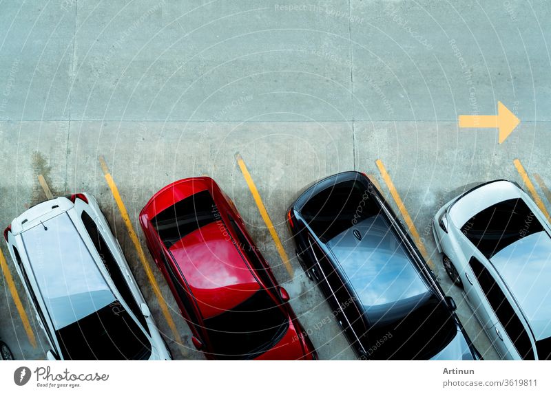 Draufsicht auf ein auf einem Betonparkplatz geparktes Auto mit gelber Linie des Verkehrsschildes auf der Straße. Draufsicht auf das Auto in einer Reihe auf dem Parkplatz. Kein freier Parkplatz. Außerhalb des Parkplatzes.