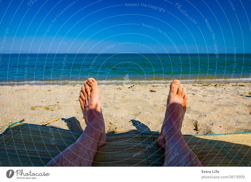 Männerbeine am Strand, Entspannung am Sandstrand Erwachsener Windstille sorgenfrei Küste Küstenlinie farbenfroh genießen Fuß schäumen Feiertag idyllisch