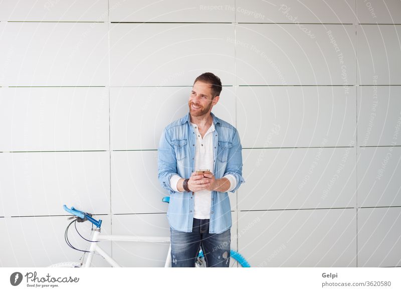 Lässiger Typ neben einem Oldtimer-Fahrrad mit dem Handy Telefon jung Mann Mobile urban Lifestyle Person männlich Großstadt im Freien Hipster Zelle