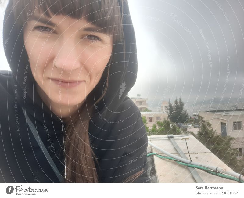 Selfie in Bethlehem selfie Hausdach Frau Frauengesicht Nasenring Kapuzenpulli stürmisch