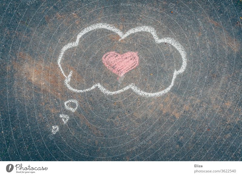 Liebe im Kopf. Mit Kreide gemalte Gedankenwolke mit einem rosa Herz darin auf Asphalt. Valentinstag. verliebt romantisch Romantik Gefühle Verliebtheit