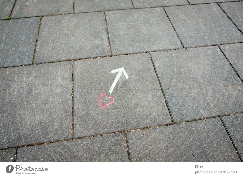 Ein Herz und ein Pfeil mit Kreide auf dem Boden gezeichnet Liebe Beziehung Wegweiser Richtung Gefühle Liebesleben Suche finden Zeichnung Konzept auf der Suche