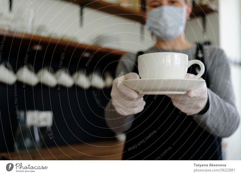 Kellnerin mit Becher in Gesichtsmaske und Handschuhen Kaffee Tasse Frau Café Restaurant Dienst Schürze schützend trinken Job Kantine Werkstatt Arbeiter Personal