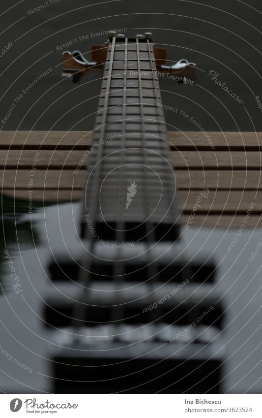 Ein E-Bass Hals fotografiert von Seitenhalter Richtung Kopf. Das Instrument ist schwarz, der Fokus liegt auf dem Griffbrett und auf den vier Seiten. EBass