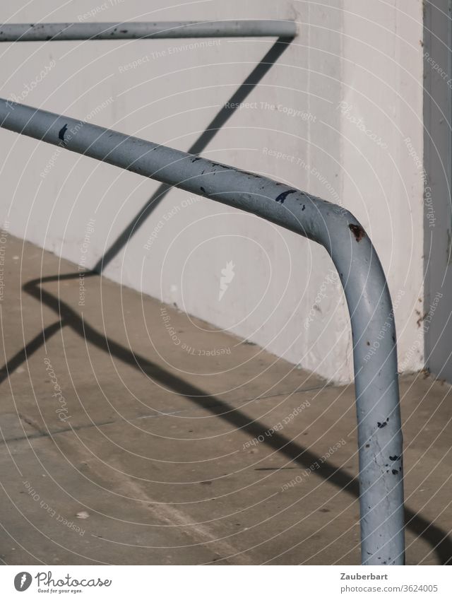 Der Schatten einer grauen Haltestange aus Eisen wirft Linien auf Wand und Pflaster Stange Straße Mauer Beton weiß Muster abstrakt halten greifen Kurve