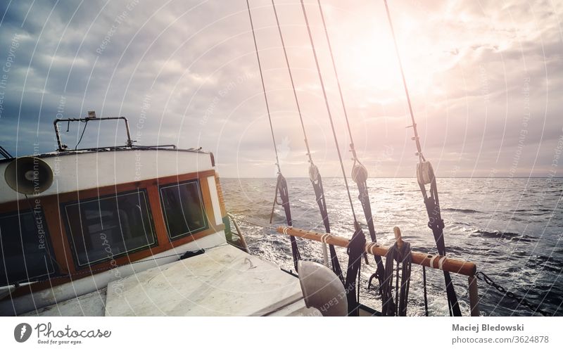 Ein altes Segelboot auf dem Ozean bei Sonnenuntergang. Wasser Natur Jacht Boot Schiff Segeln Wind Himmel romantisch Horizont winken Urlaub Sonnenlicht Sport