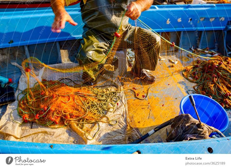 Fischer ist leerer Fisch aus dem Netz in seinem kleinen Boot - ein