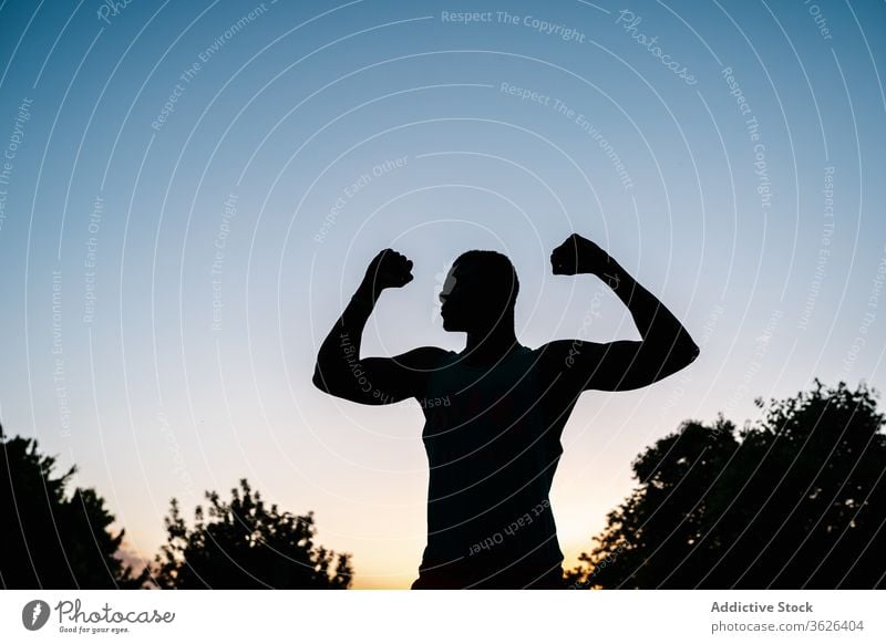 Athletischer schwarzer Mann trainiert im Park Afrikanisch muskulös Silhouette Fitness stark Biegung Körper passen Muskel Bizeps Waffen Stärke Lifestyle Truhe