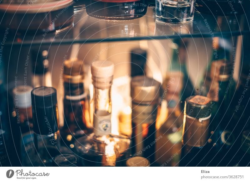 Verschiedene Flaschen mit Schnaps und Likören voller Alkohol in einem Regal in einer Bar. Schnapsflaschen alkoholisch Sammlung Glas Korken beleuchtet Licht