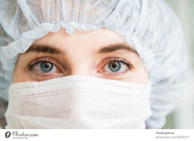 Nahaufnahmeportrait einer jungen Chirurgin oder Assistenzärztin mit Schutzmaske und Hut medizinisch Arzt Chirurgie Frau Mundschutz Porträt Konzept Notfall