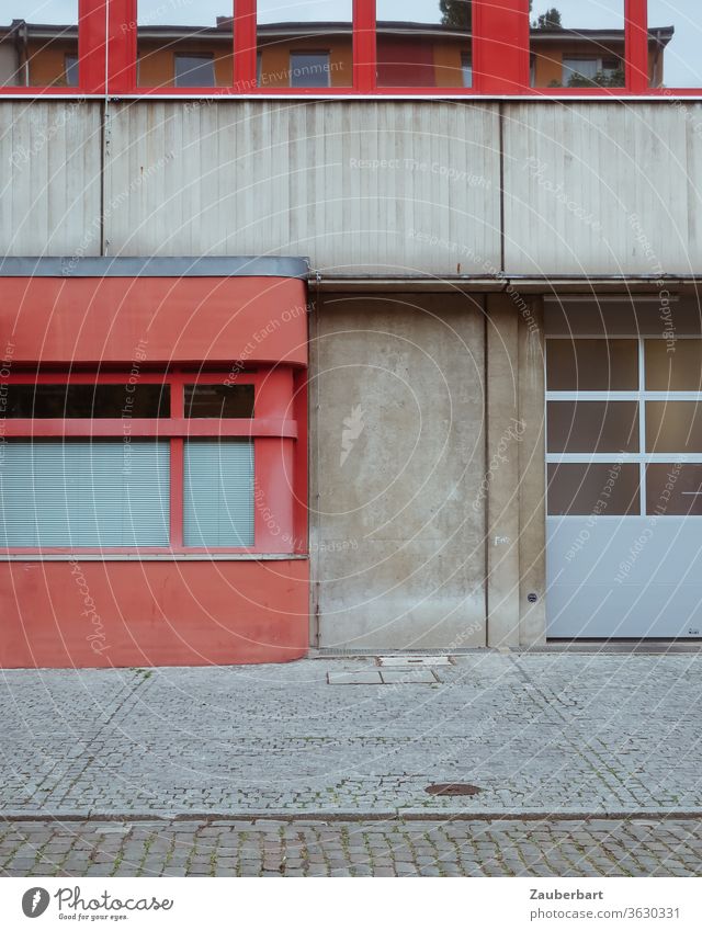 Detail der Fassade eines Feuerwehrgebäudes in Berlin Neukölln in rot und grau Beton Wand Straße Pflaster Tor Fenster Spiegelung geometrisch Segmente 70er Fugen