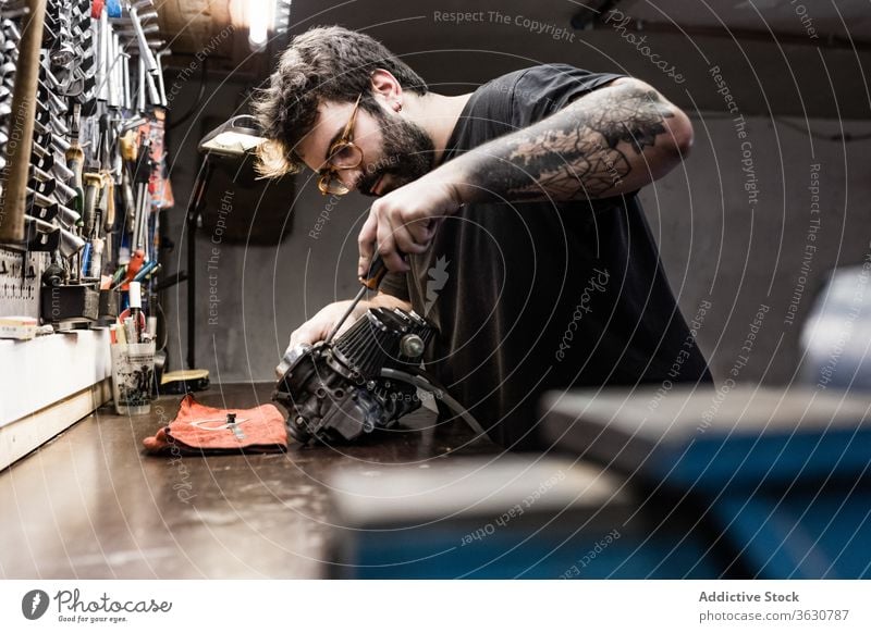 Fokussierter männlicher Mechaniker, der in der Werkstatt arbeitet Reparatur Meister Detailaufnahme Mann Fahrzeug Hobelbank fixieren brutal Seite Arbeit