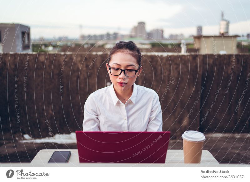 Geschäftige Frau mit Laptop arbeitet auf dem Dach Arbeit benutzend Geschäftsfrau formal Dachterrasse Gerät Apparatur Brille Business asiatisch jung Internet