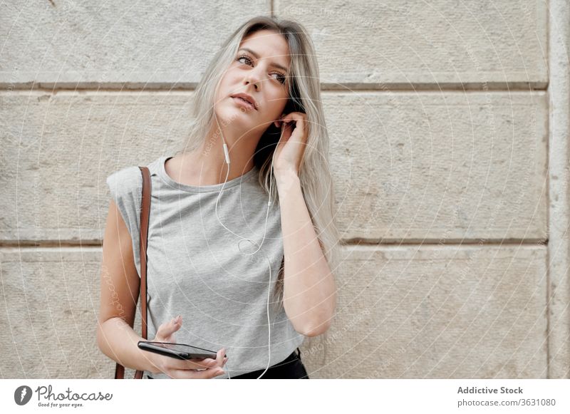 Frau mit Smartphone auf der Straße stehend zuhören Großstadt benutzend jung Glück Stil Nachricht Browsen Handy Lifestyle Gerät Apparatur Musik urban Lächeln