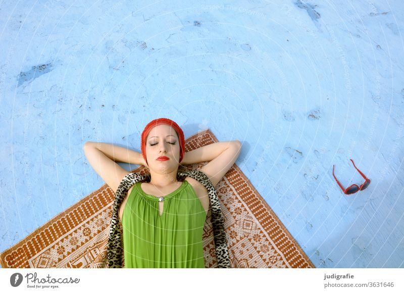 Das Mädchen mit der schönen roten Badekappe und grünem Badeanzug sonnt sich im leeren Nichtschwimmerbecken. Eine Sommerliebe. Frau Badebekleidung Badehaube Haut