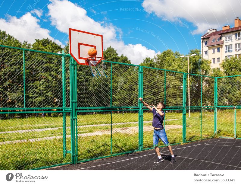 junger Mann, der an einem sonnigen Sommertag im Freien Basketball spielt Straße Menschen urban Großstadt Person Erwachsener Lifestyle Glück männlich Freizeit