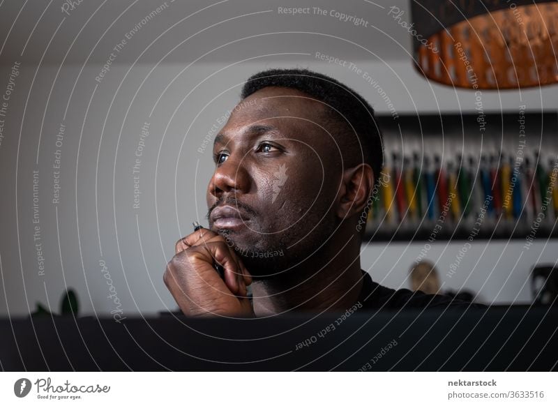 Porträt eines schwarzen Mannes, der mit der Hand auf dem Kinn denkt 1 Mensch Hand am Kinn afrikanische ethnische Zugehörigkeit Lifestyle 20-30 Jahre alt