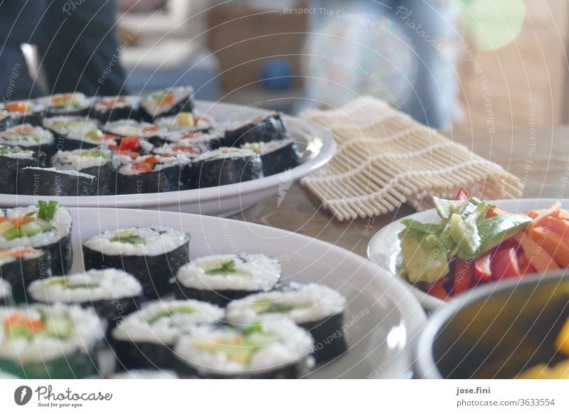 selbstgemachtes vegetarisches Sushi mit verschiedenem Gemüse und Sushimatte im Hintergrund Gericht Essen zubereiten hausgemacht Ernährung Mahlzeit