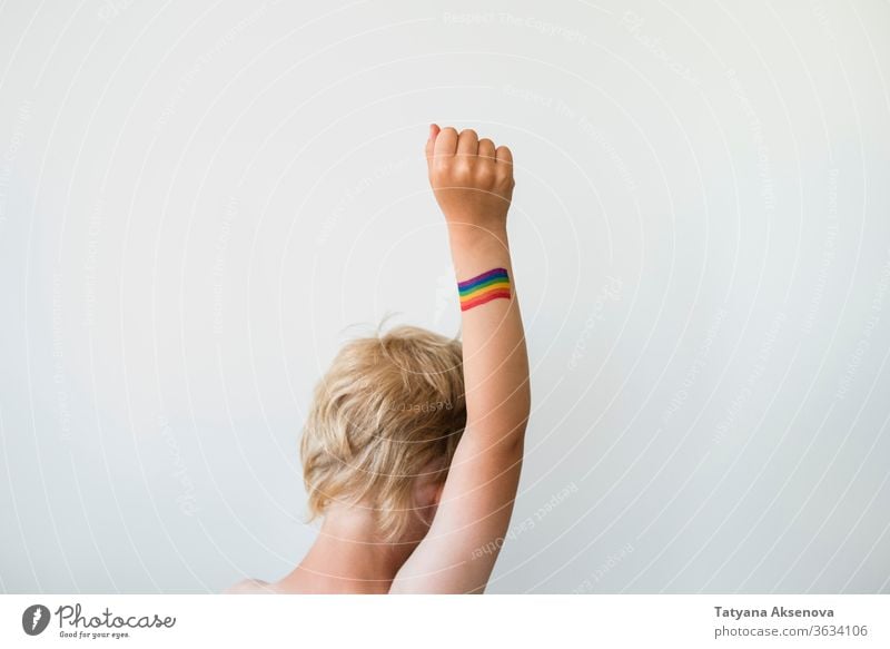 Aufgerichtete Kinderhand mit Regenbogen-Tattoo der LGBTQ-Stolzflagge Fahne lgbtq Freiheit schwul lesbisch Homosexualität Symbol Hand angehoben Rechte farbenfroh