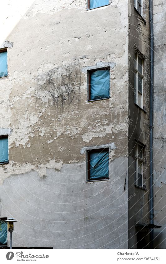 Alt | Hausfassade mit blätterndem Putz, mit blauen Planen statt Fenstern und einer Lampe hausfassade Fassade alt abblättern marode zugehängt verhängt Regenrinne