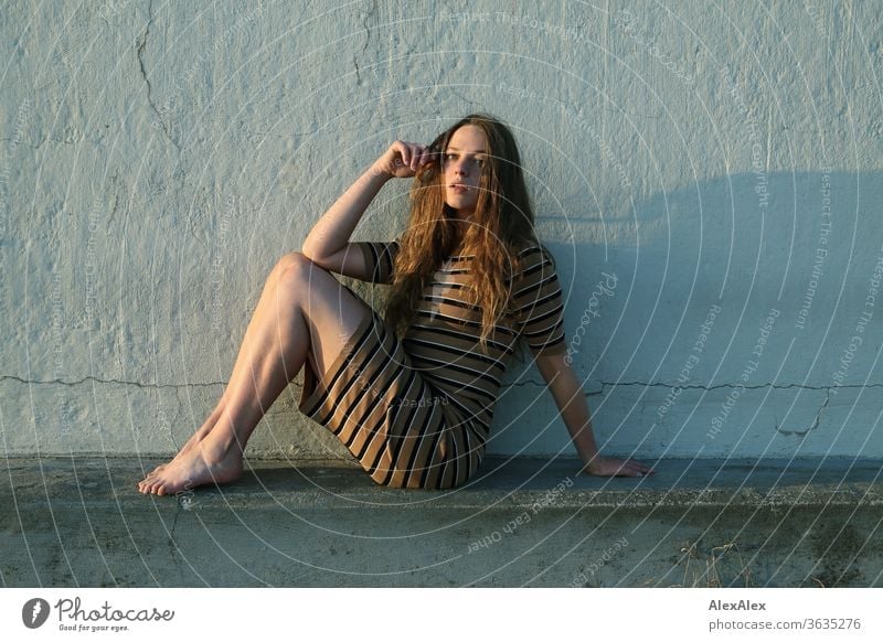 Portrait einer jungen Frau am Strand auf einer Betonmauer sitzt intensiv Mädchen Erwachsene Porträt Tag Haut Sonnenlicht selbstbewußt Zentralperspektive