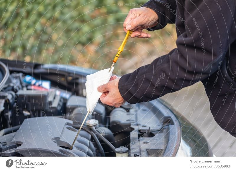 Mann kontrolliert Ölstand am Auto Laufwerk Autos PKW schwarz Überprüfung Benzin prüfen Brennstoff kaufen Filter Gas Hand praktisch Industrie Flugzeugwartung KFZ