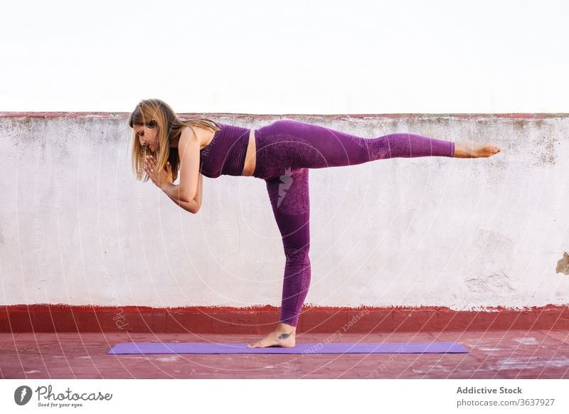 Ruhige, Yoga praktizierende Frau in Kriegerposition Krieger-Pose üben Gleichgewicht Namaste gestikulieren Gesundheit Unterlage Terrasse Harmonie Asana