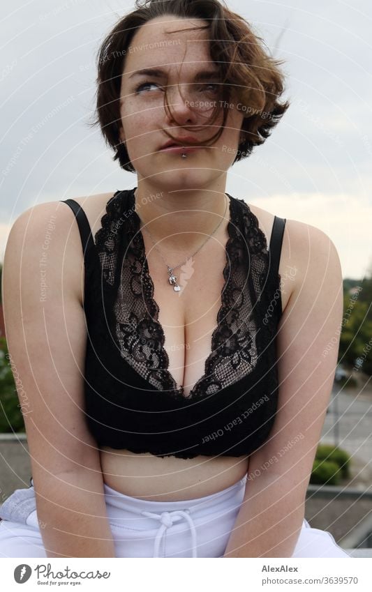 Portrait einer jungen, sommersprossigen Frau auf einem Dach junge Frau Top windig Haare brünett schön intensiv Jugendliche 18-25 Jahre Dekolleté