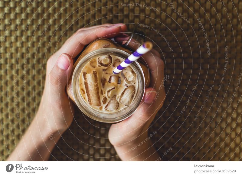 Flachlegung eines gemauerten Glases mit Eistee oder Kaffee, selektiver Fokus Getränk Koffein kalt cool trinken Frau Finger Lebensmittel Hände Gesundheit