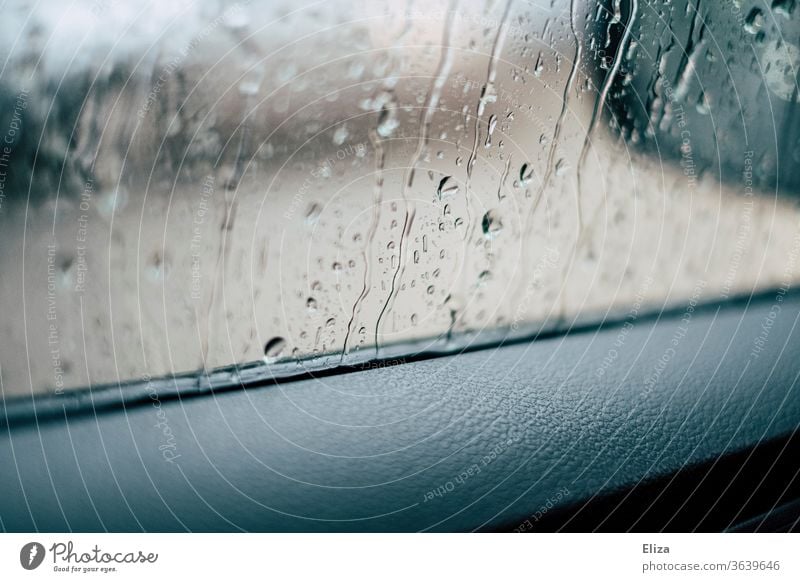 Blick aus dem Autofenster bei Regen Regentropfen Fensterscheibe schlechtes Wetter PKW Fahrzeug nass Herbst autofahren Wassertropfen Tropfen Detailaufnahme