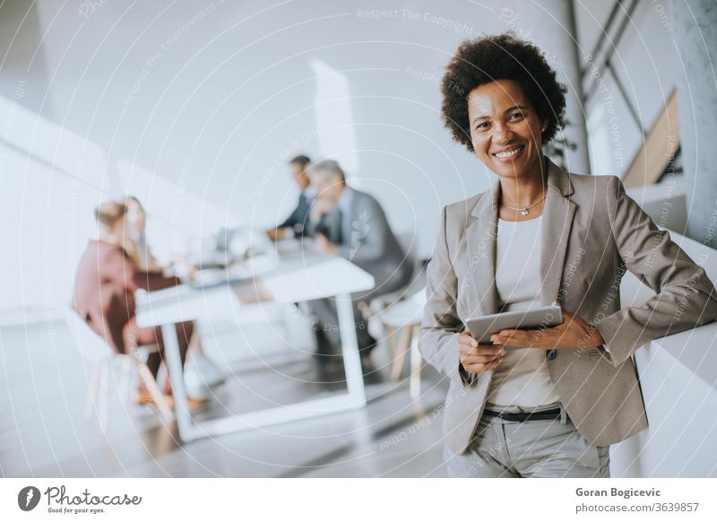 Junge afroamerikanische Geschäftsfrau steht mit digitalem Tablet in einem modernen Büro Tablette Frau Business schwarz Technik & Technologie Arbeit jung