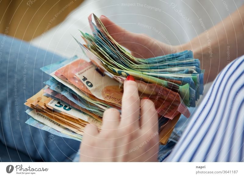 Reisekasse | Junge Frau hält einen Stapel Geldscheine in den Händen und zählt durch. Euro Bargeld zählen sparen Einkommen Reichtum bezahlen kaufen sparsam reich