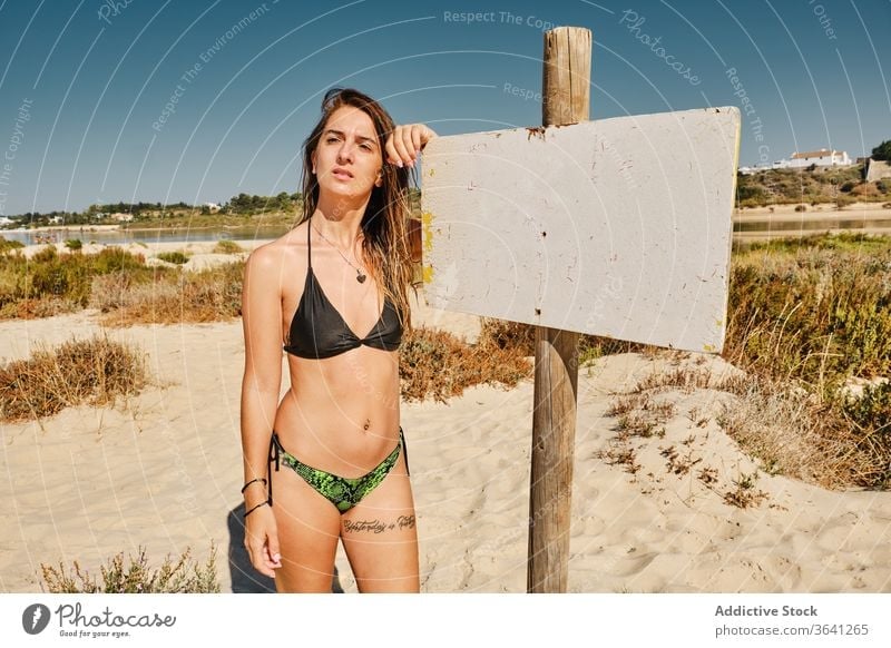Fröhliche Reisende im Badeanzug am Strand MEER Zeichen Frau Bikini Tourismus Strandpromenade Urlaub Sommer Sand schlank reisen Feiertag Badebekleidung Küste