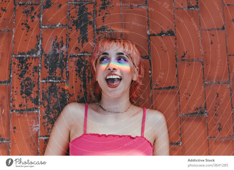 Glückliche Frau auf Ziegelboden liegend tausendjährig rosa Haare sorgenfrei Regenbogen expressiv anders kreativ modern trendy Straße Stil Lächeln Dame urban
