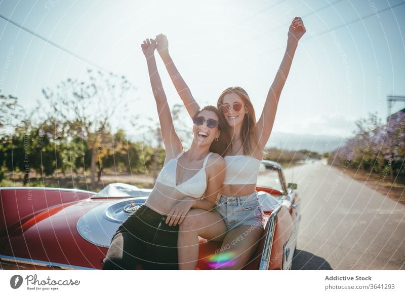 Entzückte Freundinnen haben im Sommer Spaß auf der Straße Urlaub genießen Frauen Cabriolet PKW sorgenfrei heiter Zusammensein Feiertag Lächeln Glück reisen
