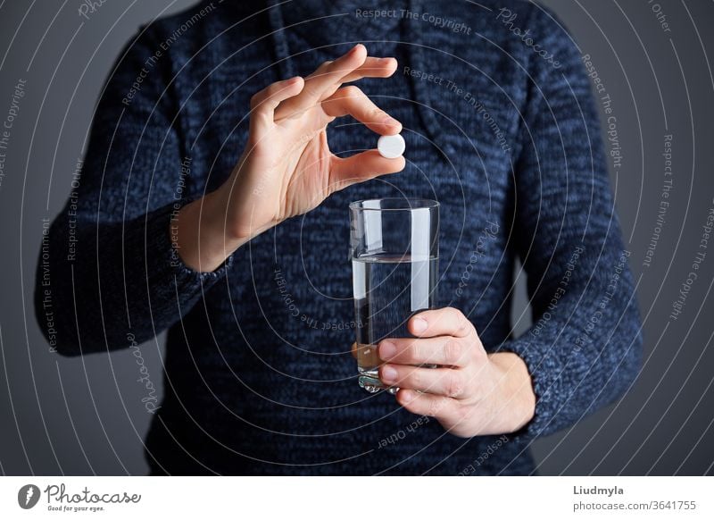 Mann bereit, die Pille in Wasser aufzulösen. Lösliche weiße Pille und ein Glas Wasser in der Hand. Brausetablette Aspirin in einem Glas Wasser Business jung
