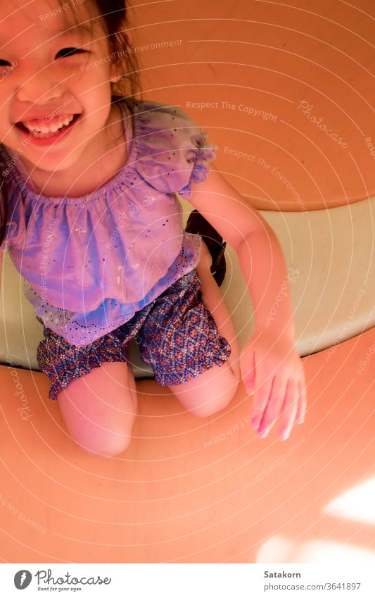 Kleines asiatisches Mädchen spielt gerne auf dem Spielplatz im Freien wenig Lächeln Kinder Glück Spaß genießen niedlich Spielen Aktivität Kindheit spielerisch