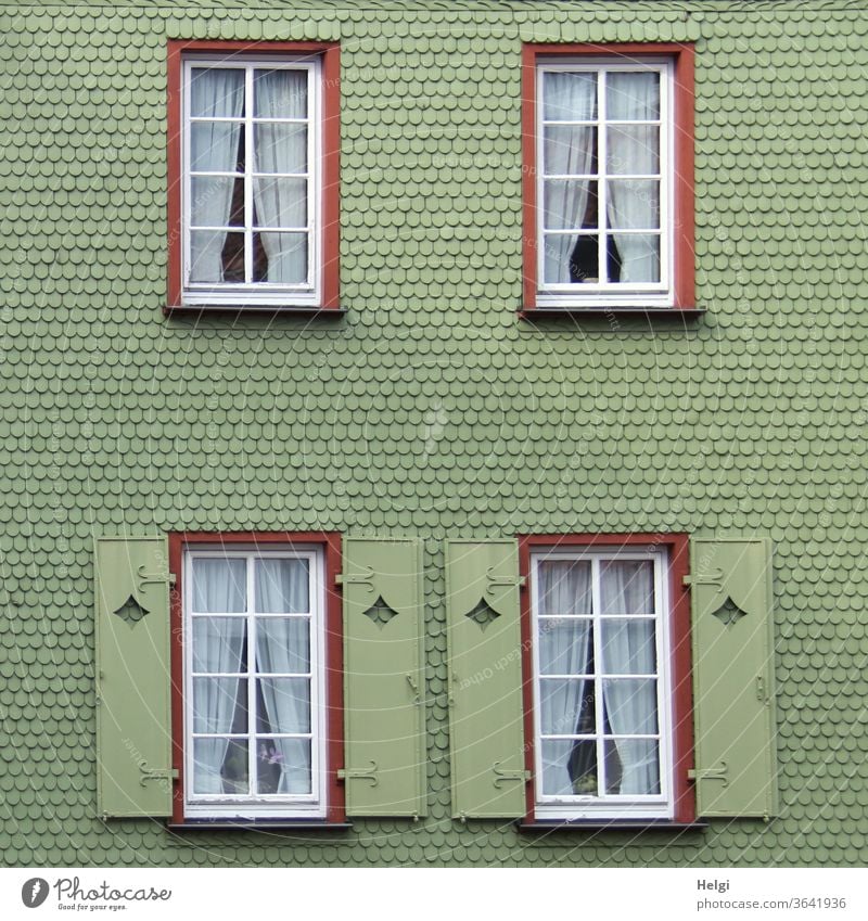grüne Schindelfassade mit Fenstern und Fensterläden | Symmetrie Fassade Haus Gebäude Schindeln Menschenleer Außenaufnahme Architektur Wand Bauwerk Stadt