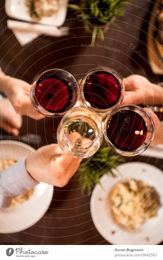 Vier Hände mit Rotwein rösten über dem servierten Tisch mit Essen rot Restaurant Party Wein Beteiligung Ansicht Top jubelt Menschen trinken Freunde Lifestyle