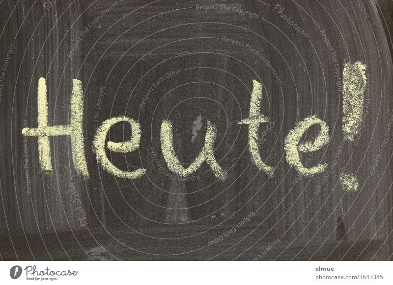 "Heute!" steht in Druckbuchstaben mit gelber Kreide geschrieben auf einer unsauber abgewischten schwarzen Tafel heute Termin Schulkreide Notiz Mitteilung