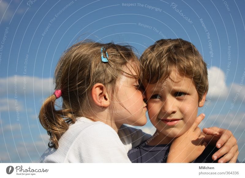 Kleines Mädchen umarmt Jungen vor blauem Himmel mit weißen Wolken 2 Mensch 3-8 Jahre Kind Kindheit berühren Küssen Lächeln Liebe Umarmen Geschwister