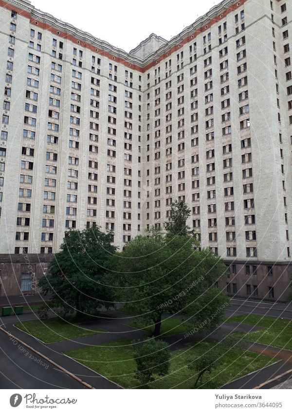 Foto eines hohen Wohnblocks mit Balkonen in Moskau. Wohnwohnungen im Hintergrund der Architektur. Gemeinsames Hausobjekt mit grauen Wänden und Fenstern. Wohnheim der Moskauer Staatsuniversität.